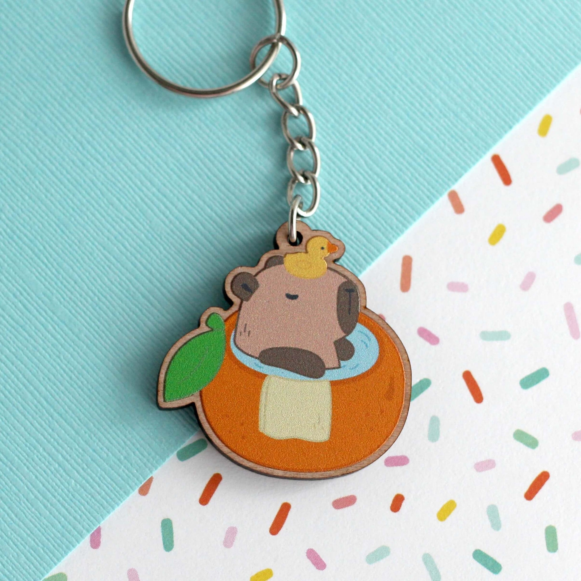 Capybara dans un porte-clés en bois de bain orange