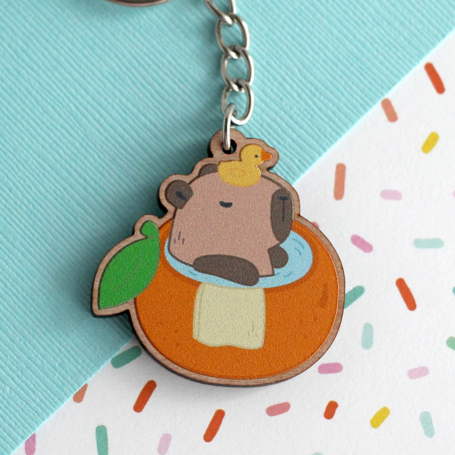 Capybara dans un porte-clés en bois de bain orange
