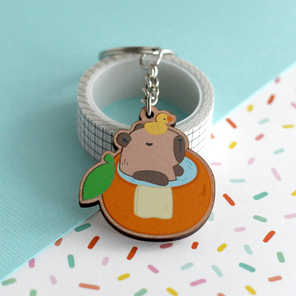 Capybara dans un porte-clés en bois de bain orange