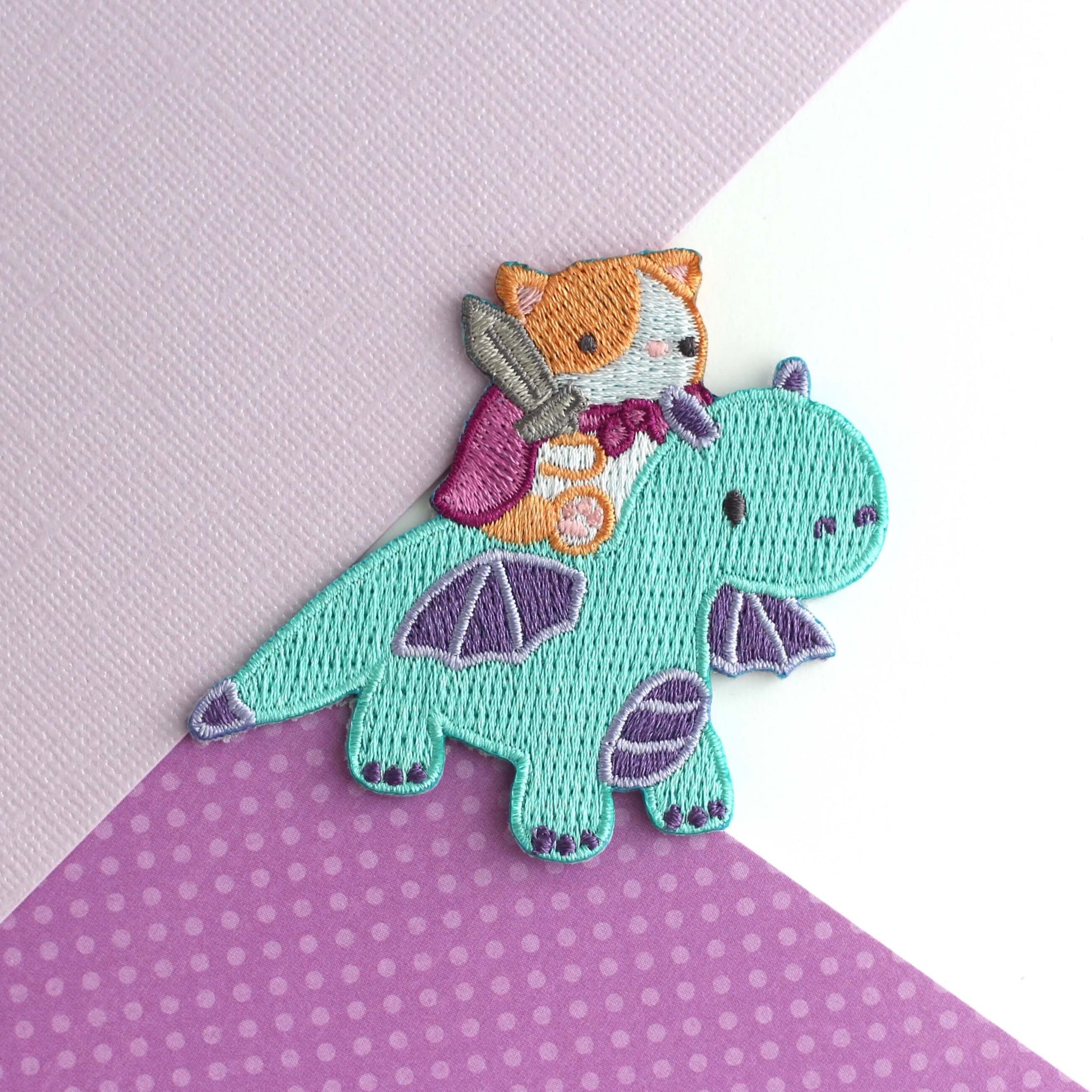 Patch thermocollant brodé représentant un chat chevauchant un dragon