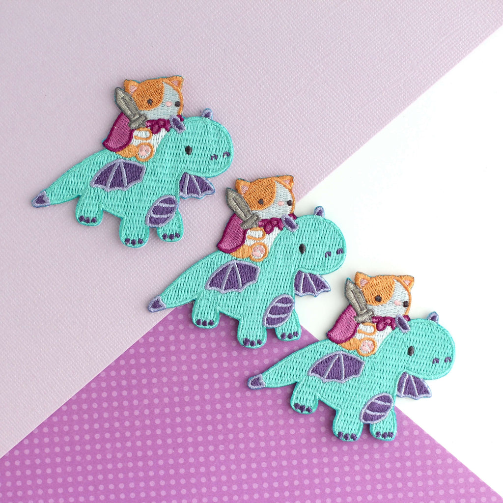 Patch thermocollant brodé représentant un chat chevauchant un dragon