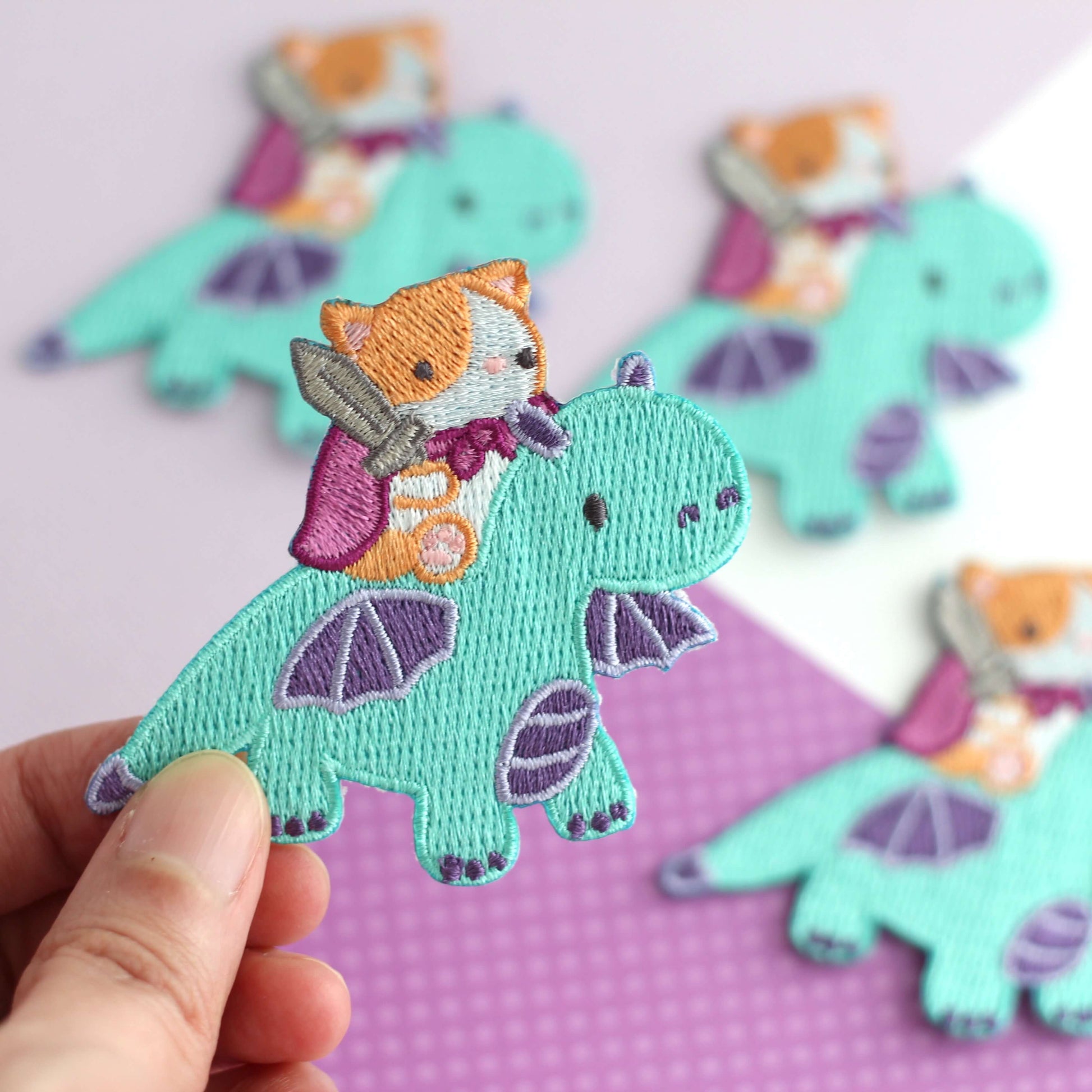 Patch thermocollant brodé représentant un chat chevauchant un dragon