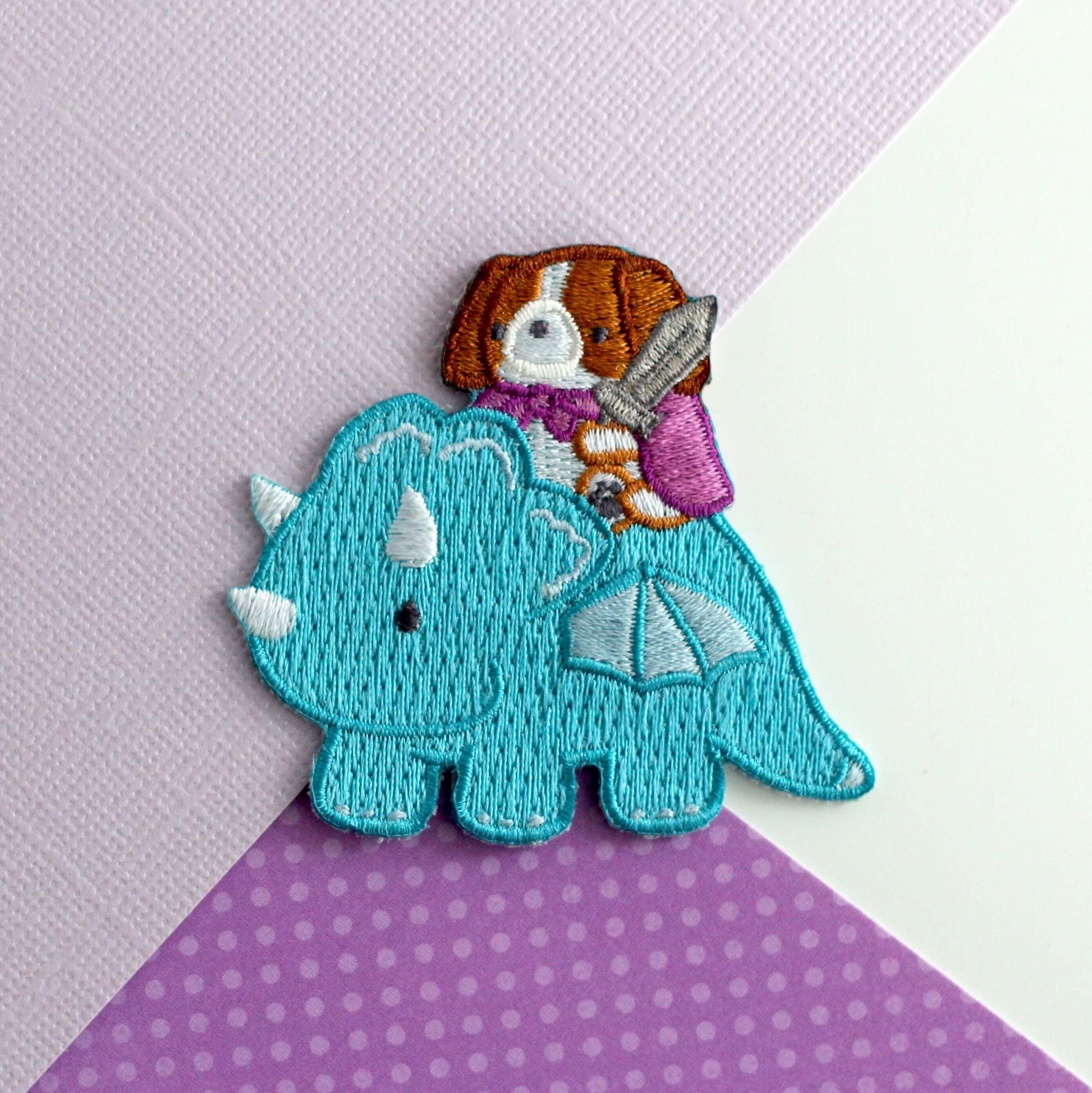 Patch thermocollant brodé représentant un Cavalier King Charles Spaniel chevauchant un dragon