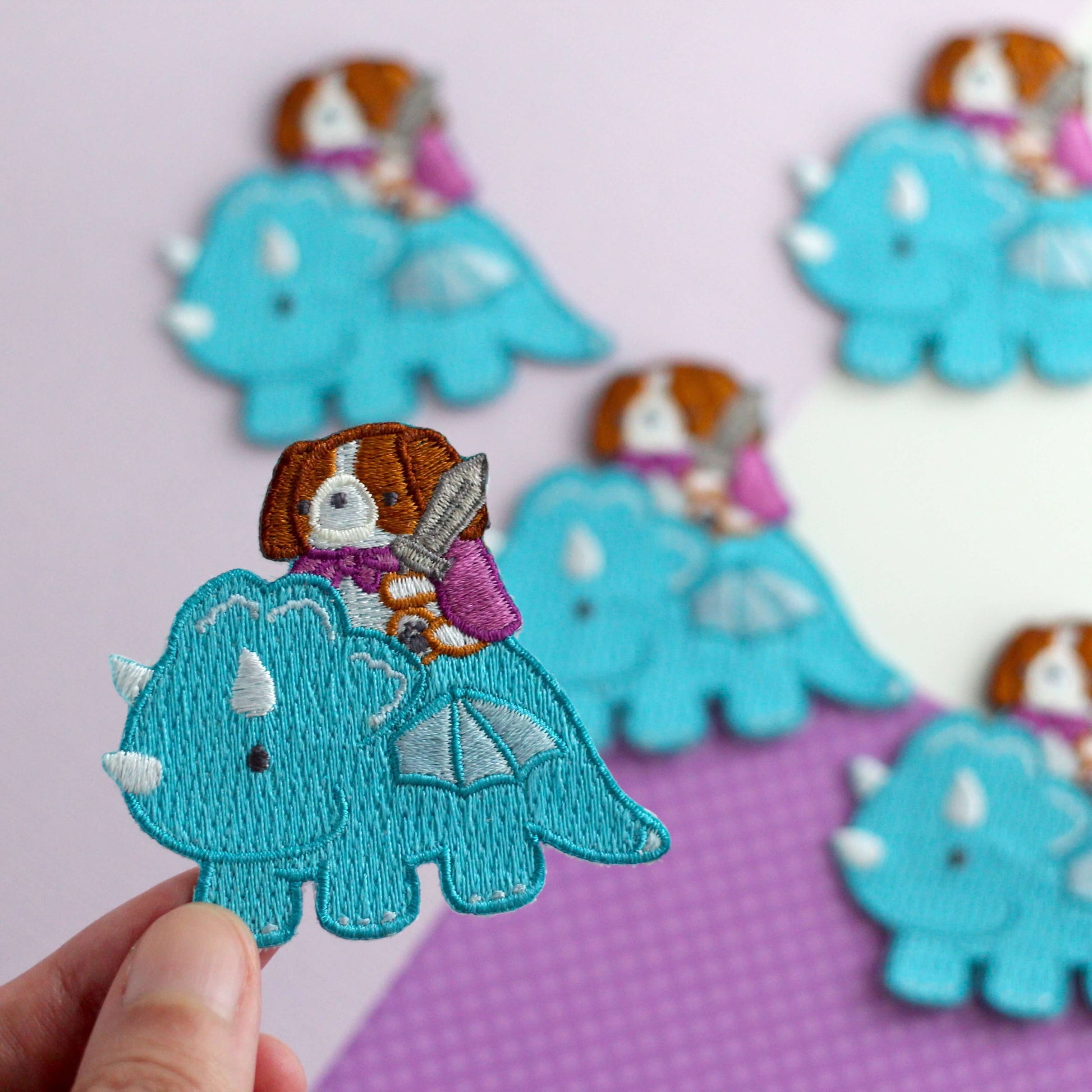 Patch thermocollant brodé représentant un Cavalier King Charles Spaniel chevauchant un dragon