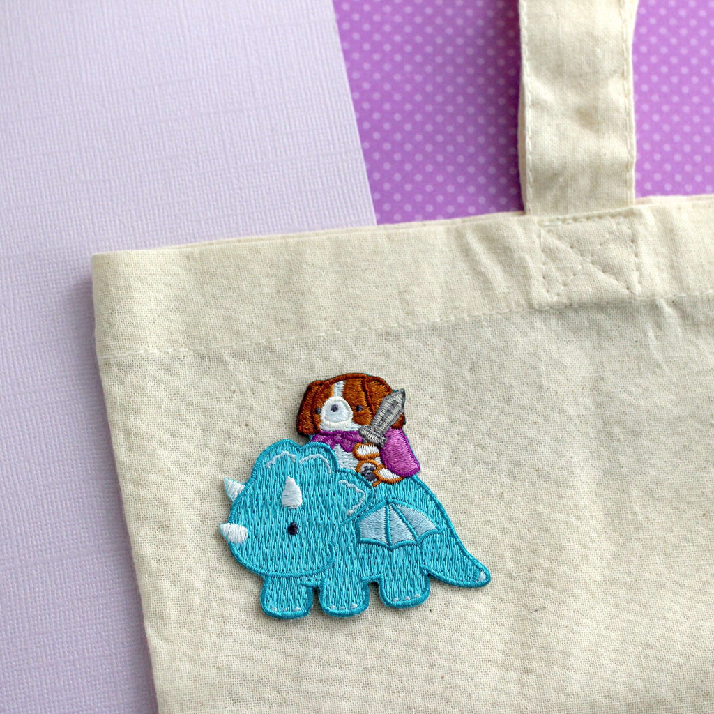 Patch thermocollant brodé représentant un Cavalier King Charles Spaniel chevauchant un dragon