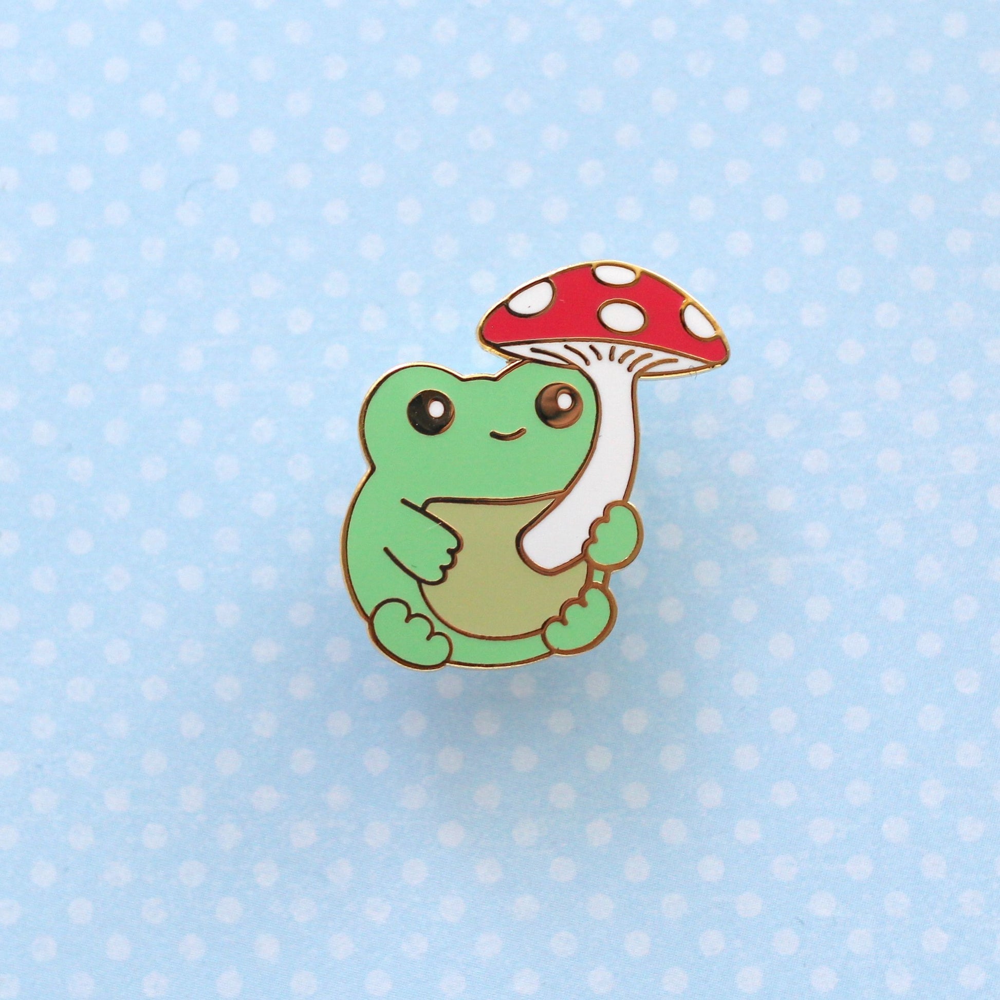 Broche en émail représentant une grenouille verte avec un champignon