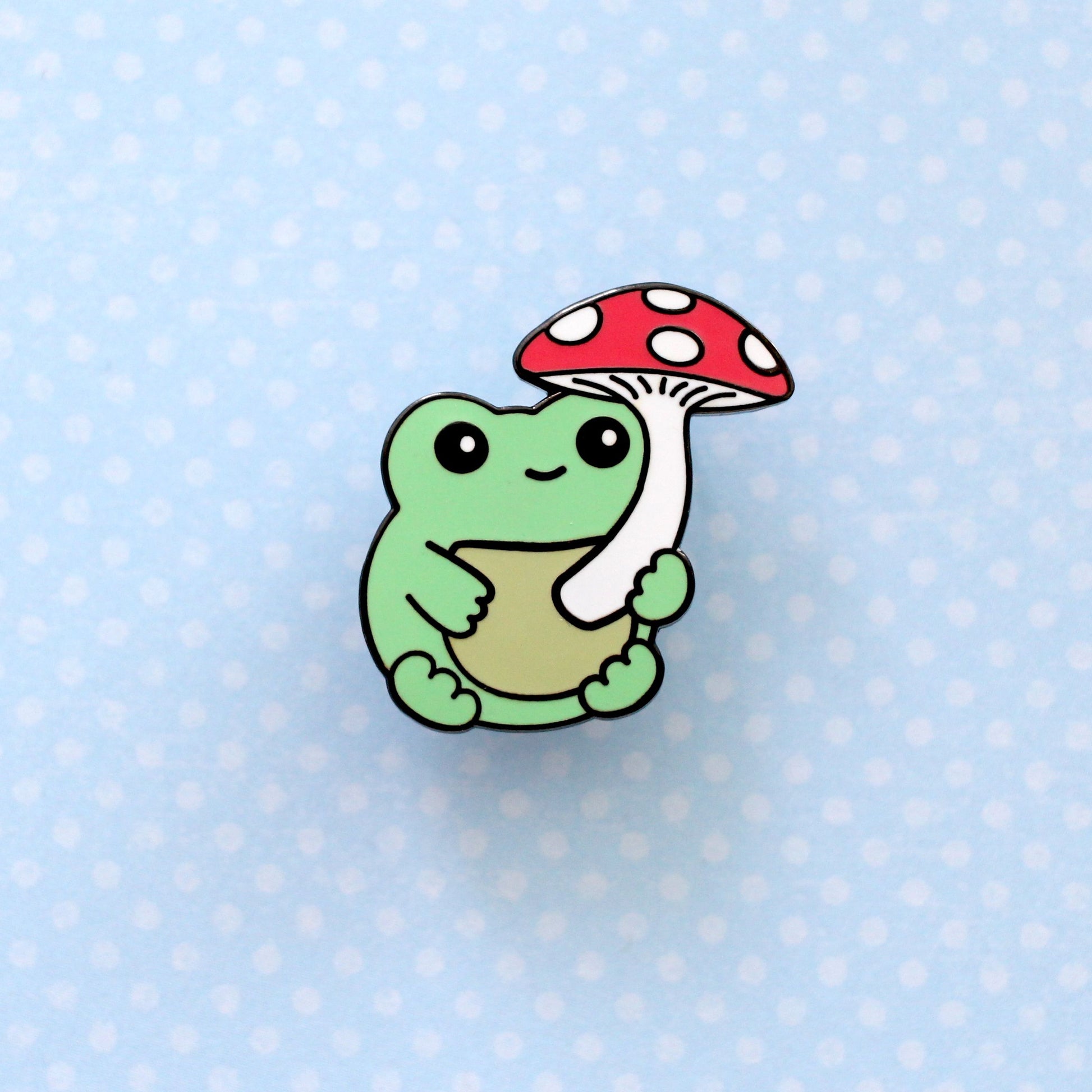 Broche en émail représentant une grenouille verte avec un champignon