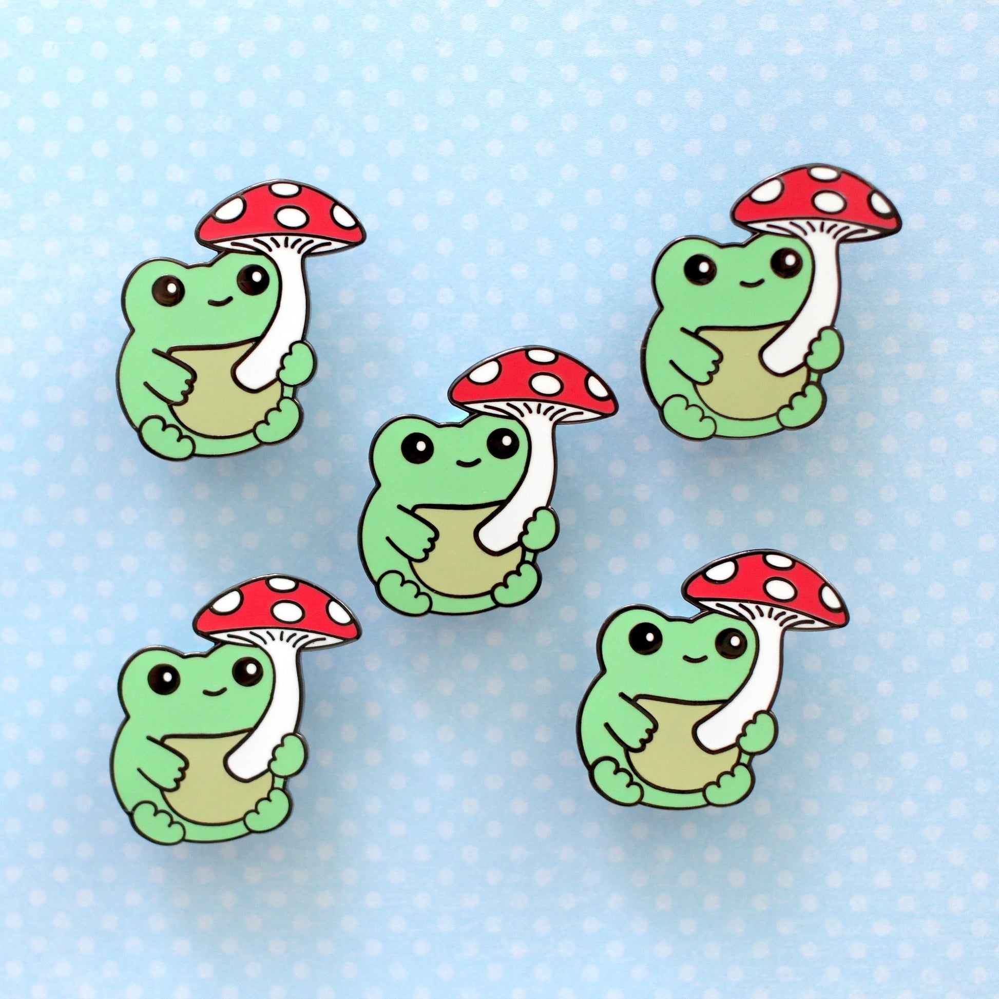 Broche en émail représentant une grenouille verte avec un champignon