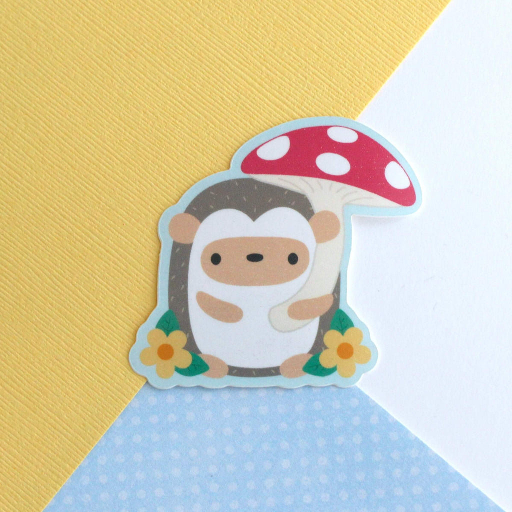 Autocollant en vinyle représentant un hérisson tenant un parapluie en forme de champignon rouge