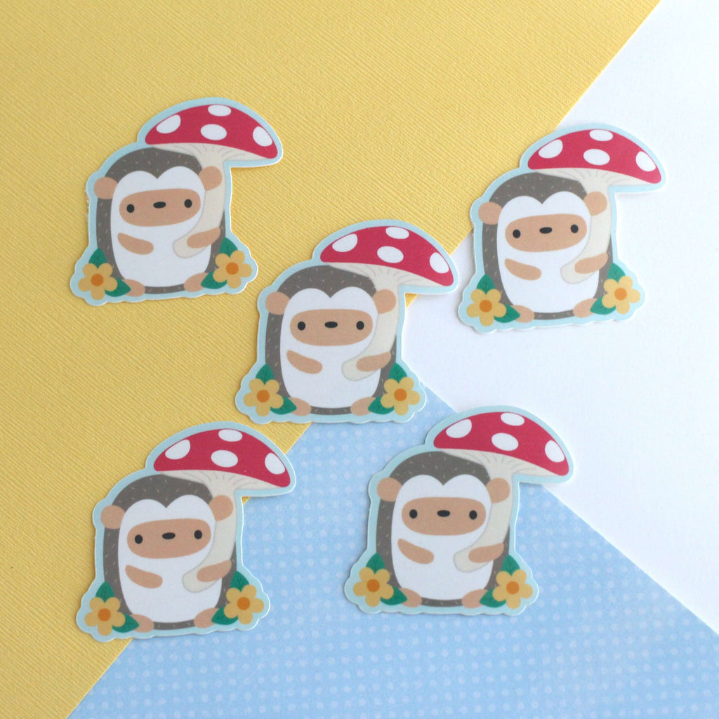 Autocollant en vinyle représentant un hérisson tenant un parapluie en forme de champignon rouge