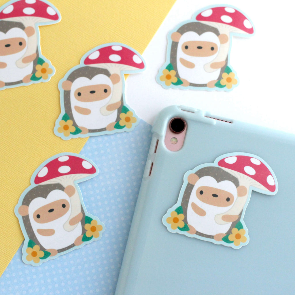 Autocollant en vinyle représentant un hérisson tenant un parapluie en forme de champignon rouge