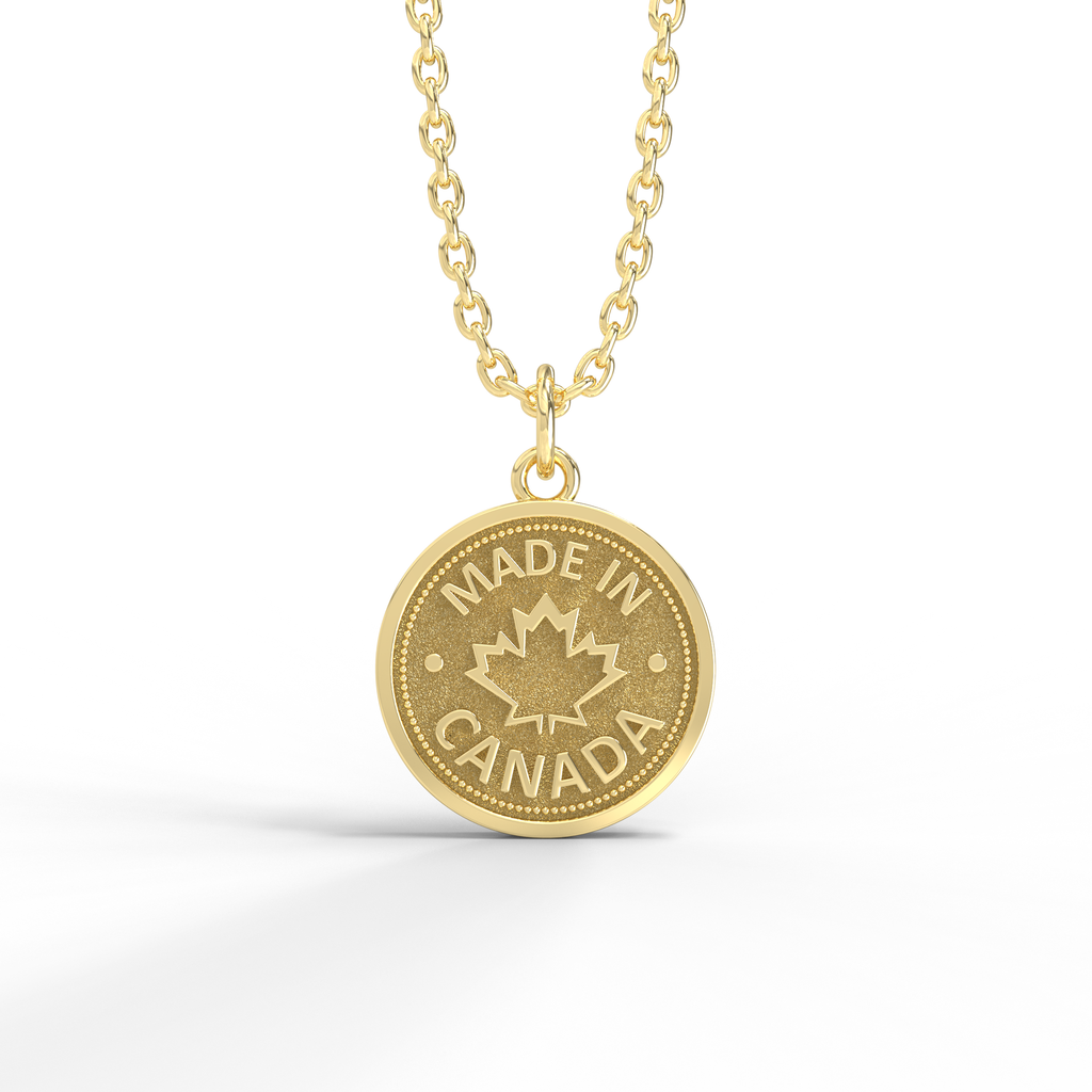 Sterling silver coin pendant with 'MADE IN CANADA' and a maple leaf design, on a silver chain against a white background