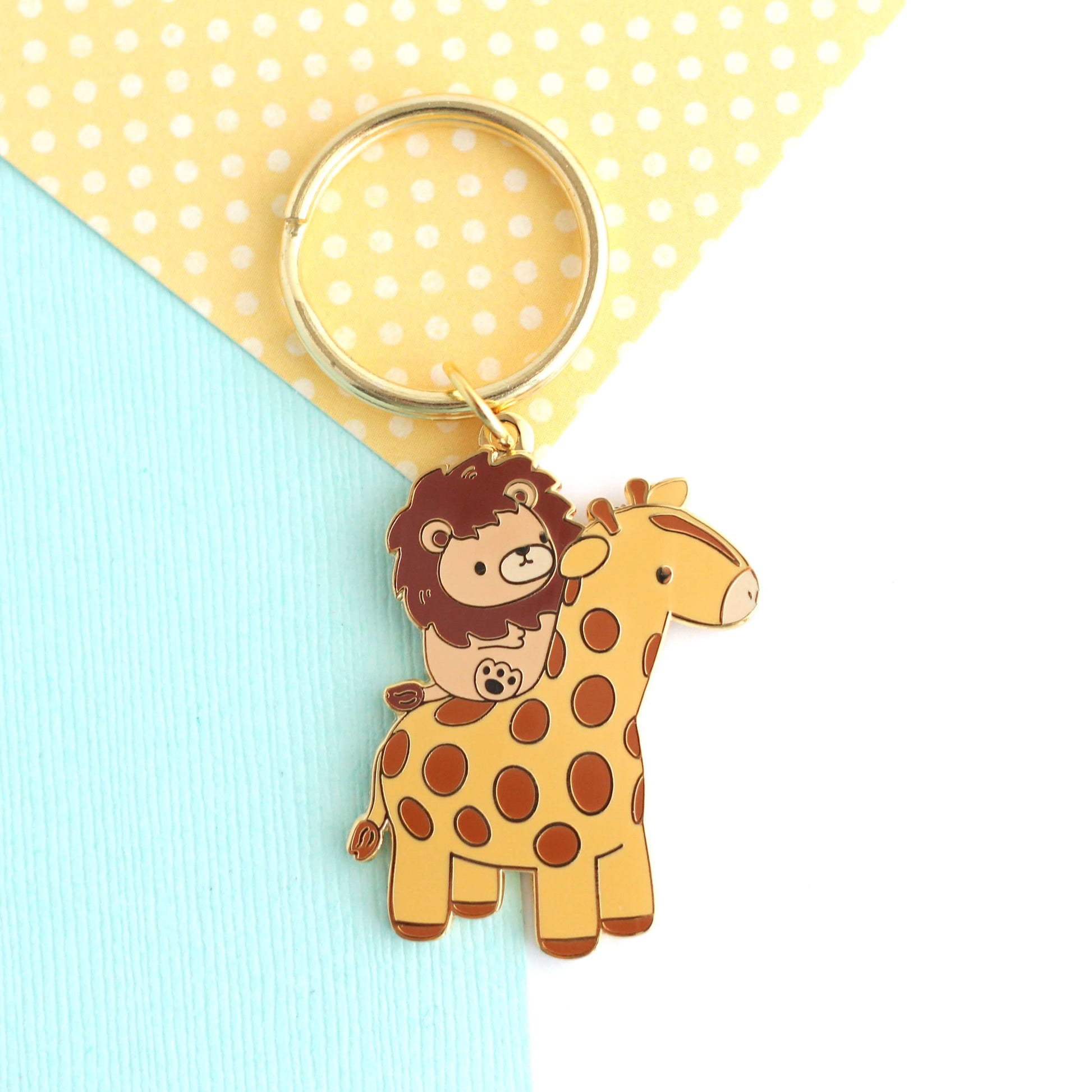 Porte-clés en émail représentant un lion chevauchant une girafe