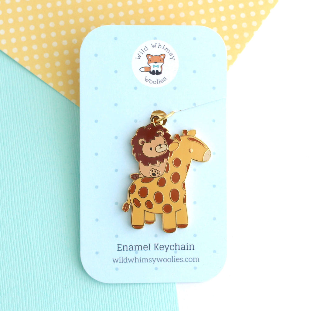 Porte-clés en émail représentant un lion chevauchant une girafe