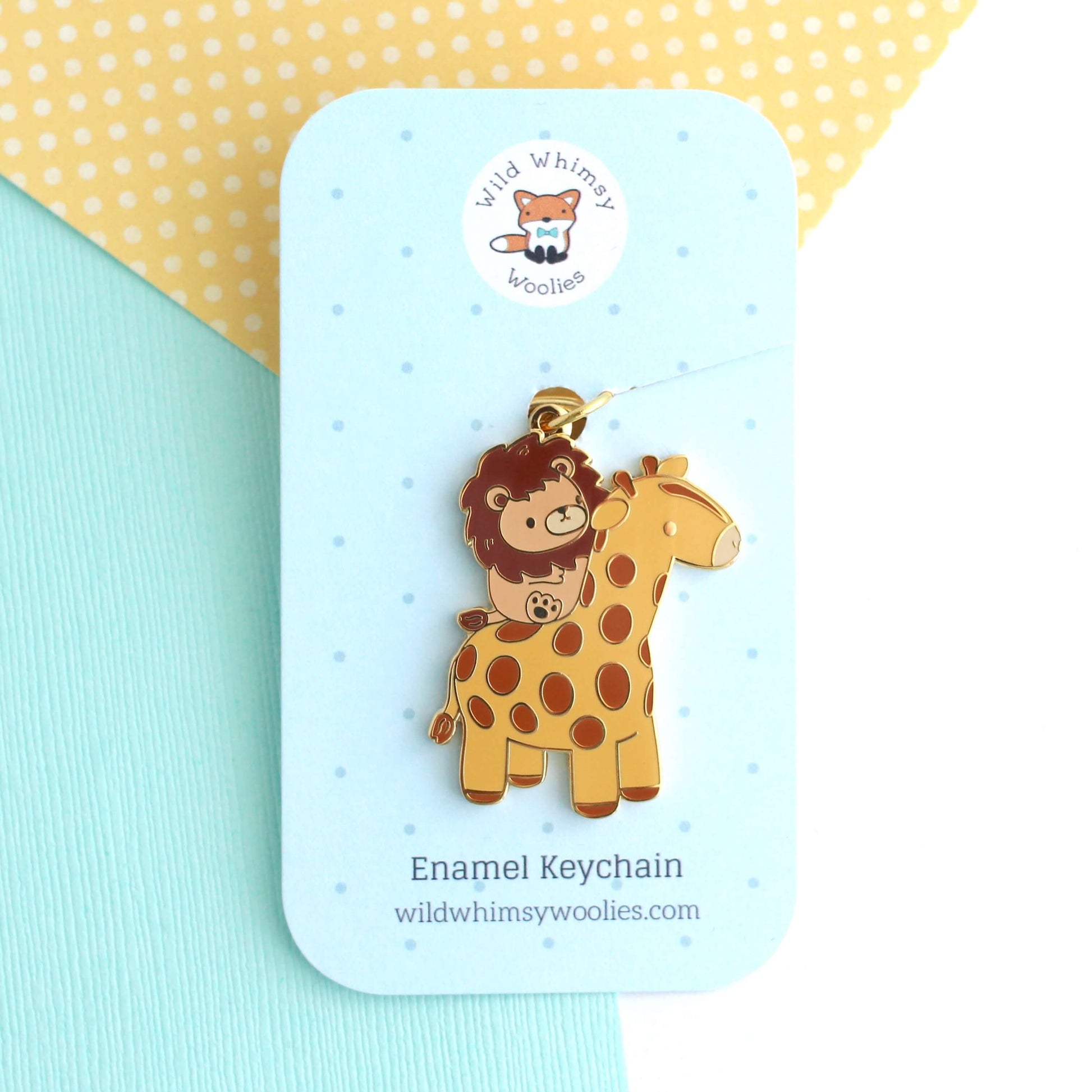 Porte-clés en émail représentant un lion chevauchant une girafe