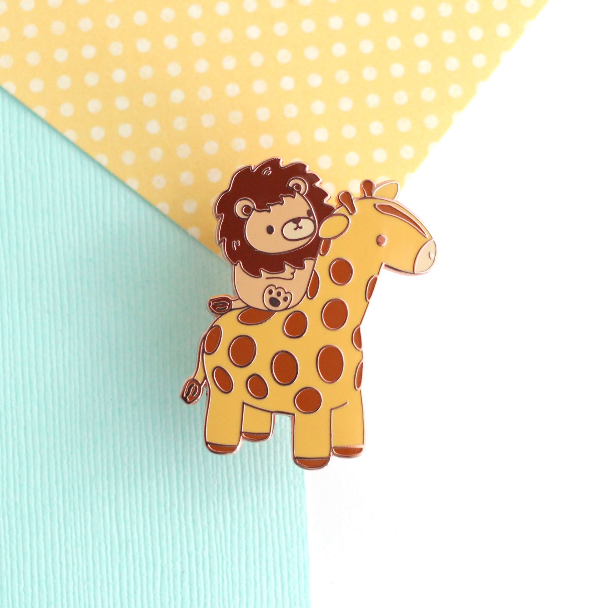 Broche en émail représentant un lion chevauchant une girafe