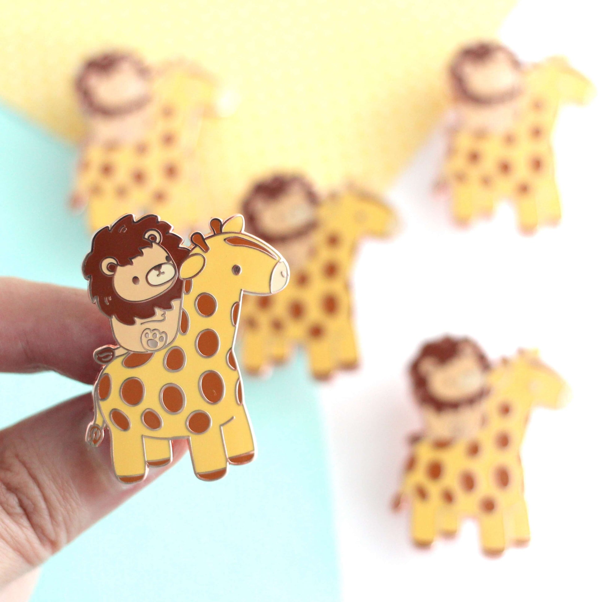 Broche en émail représentant un lion chevauchant une girafe