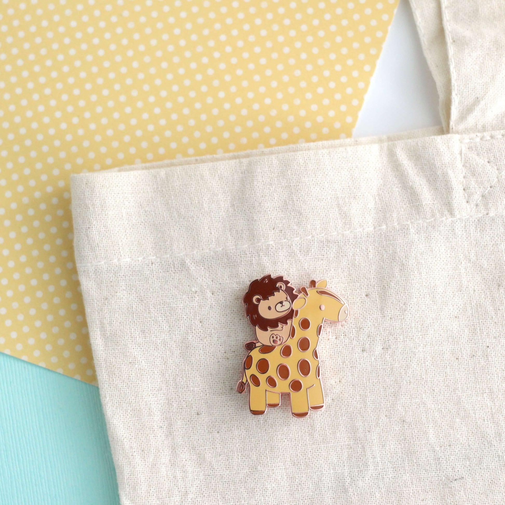 Broche en émail représentant un lion chevauchant une girafe