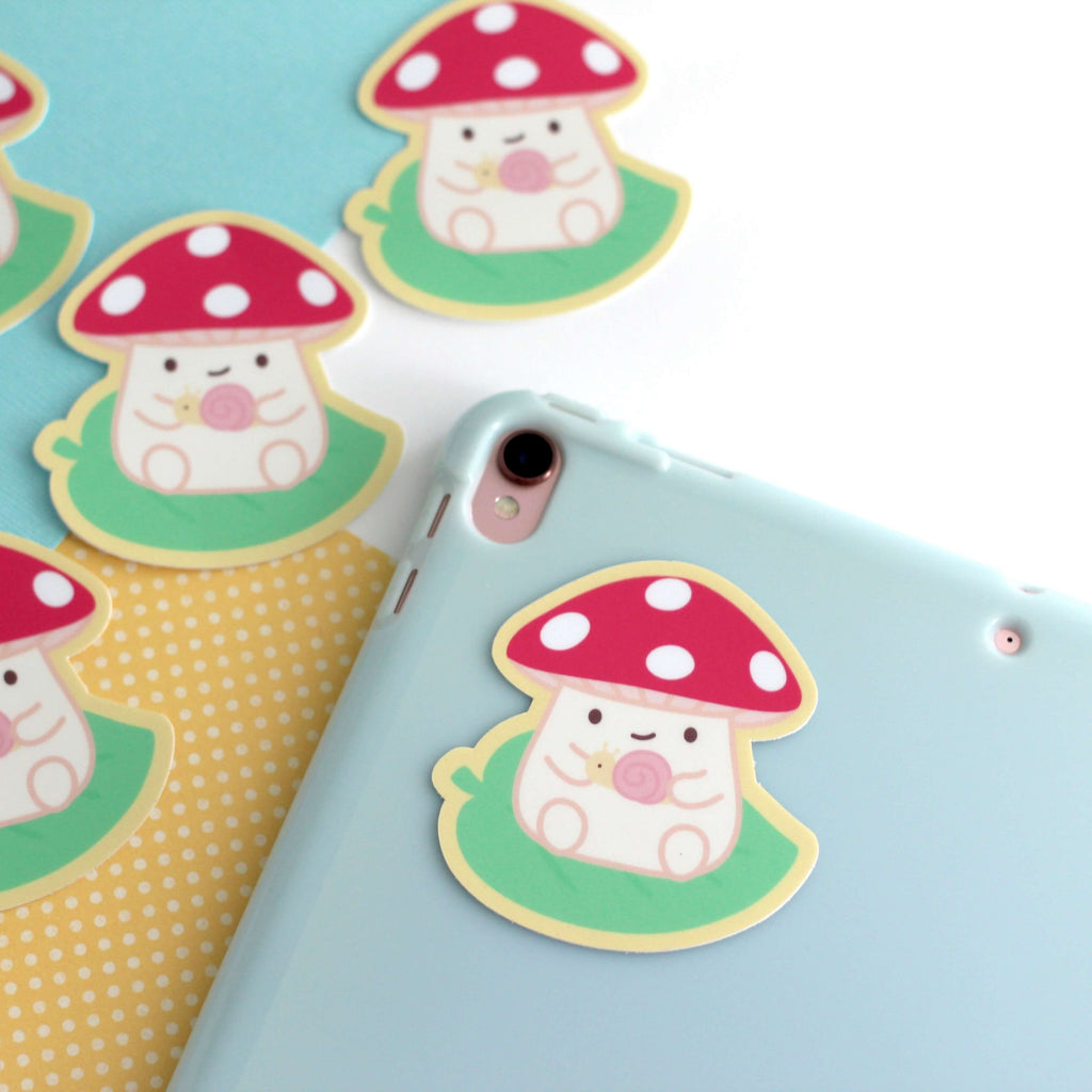 Autocollant en vinyle représentant un champignon sur une feuille tenant un escargot