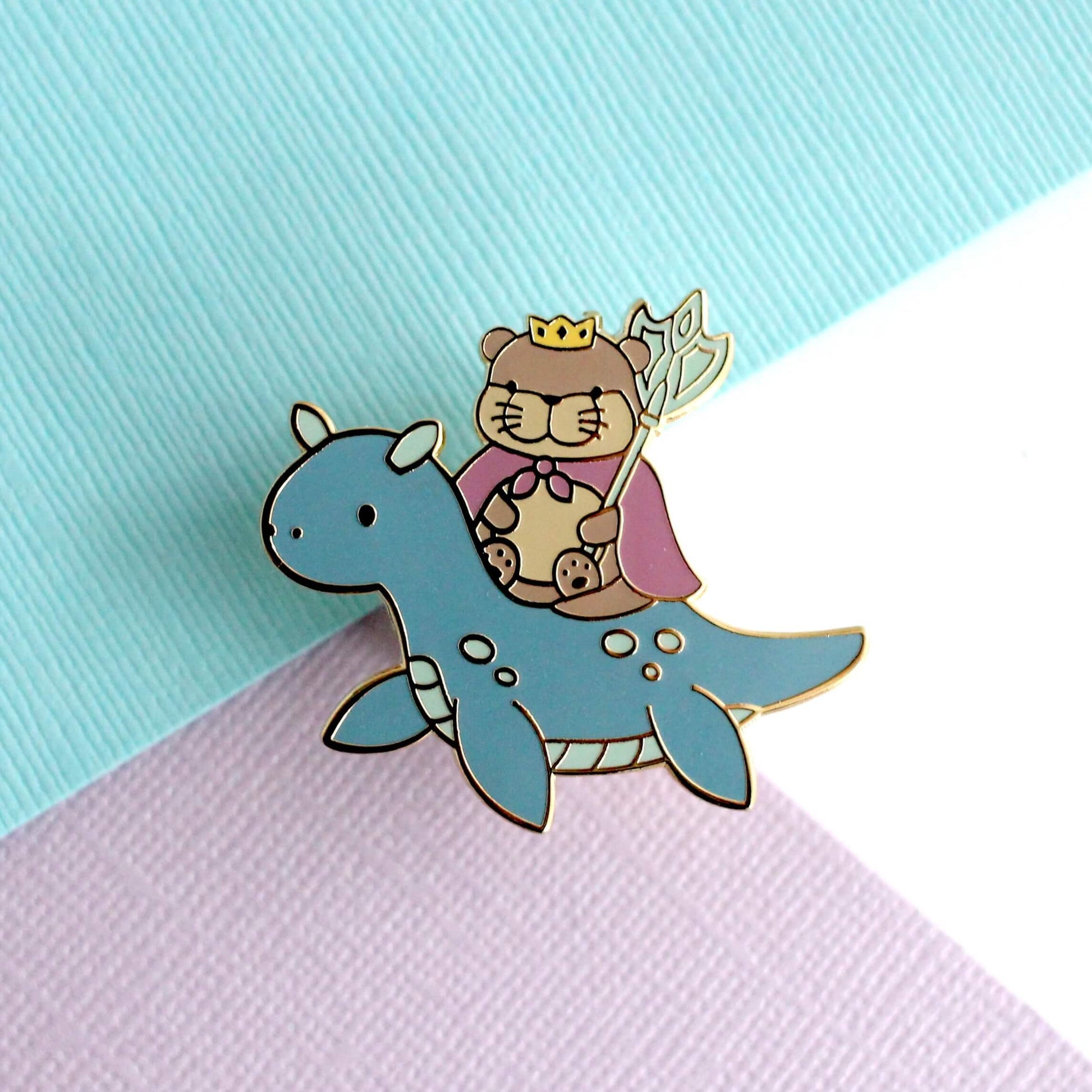 Broche en émail représentant le roi loutre chevauchant un dragon des mers (variante dragon bleu foncé)