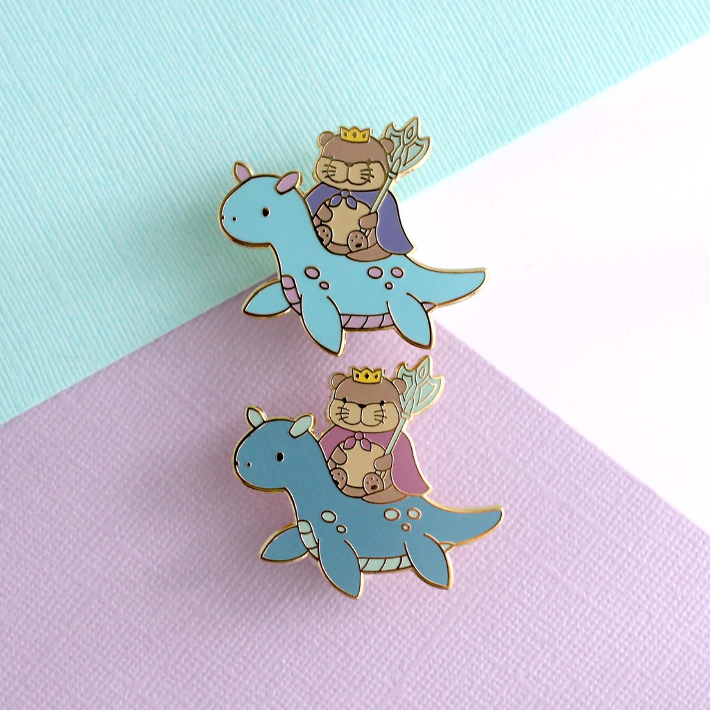 Broche en émail représentant le roi loutre chevauchant un dragon des mers (variante dragon bleu clair)