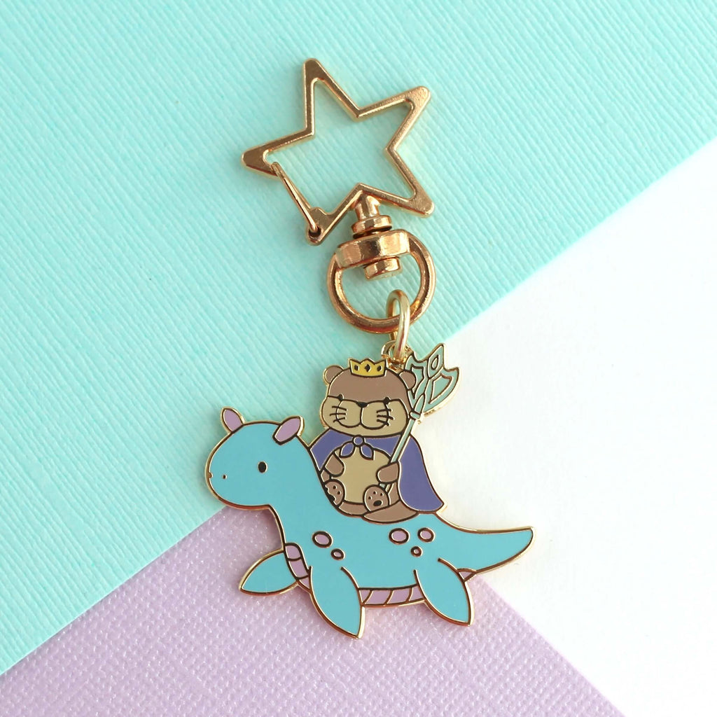 Porte-clés en émail représentant le roi loutre chevauchant un dragon des mers (variante dragon bleu clair)
