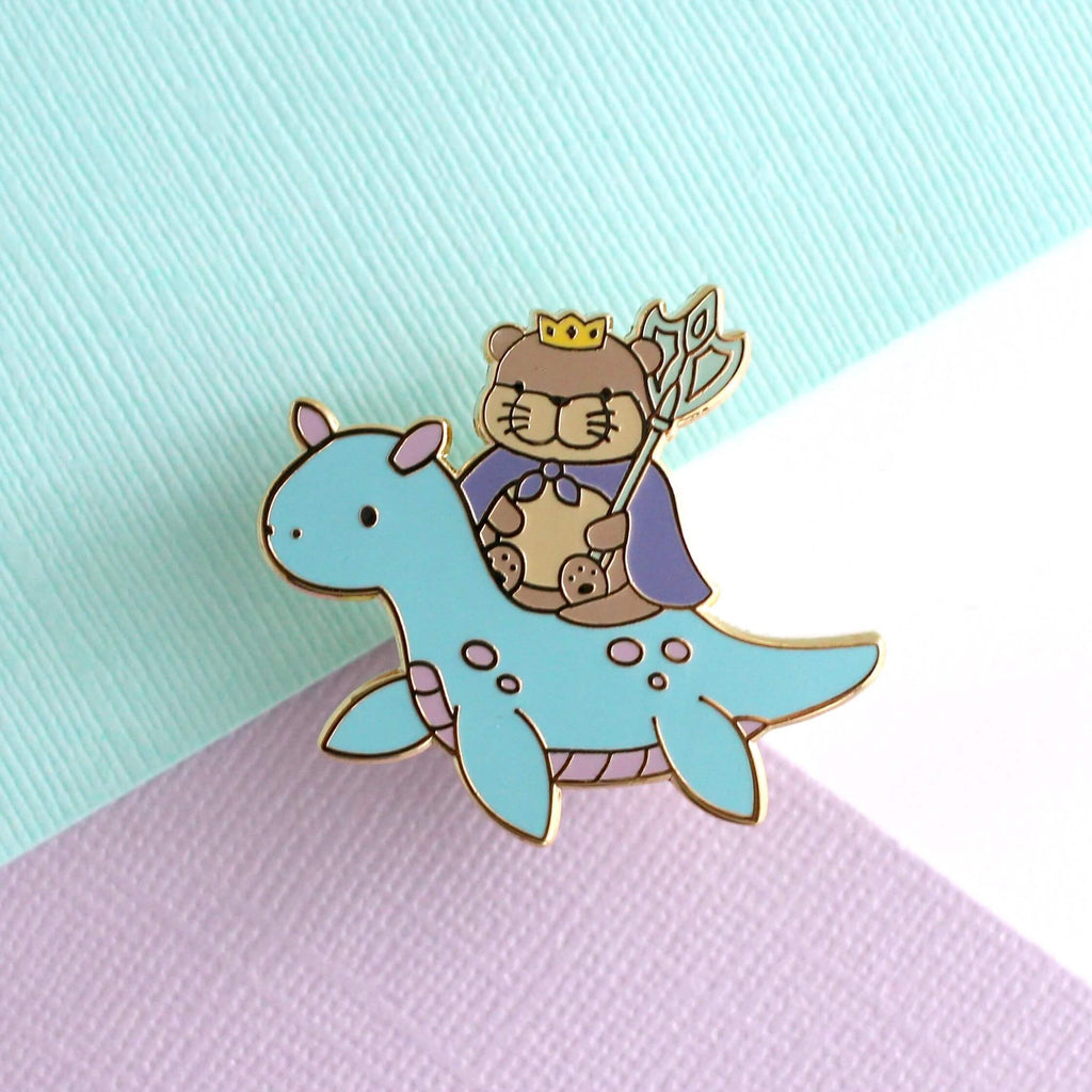 Broche en émail représentant le roi loutre chevauchant un dragon des mers (variante dragon bleu clair)