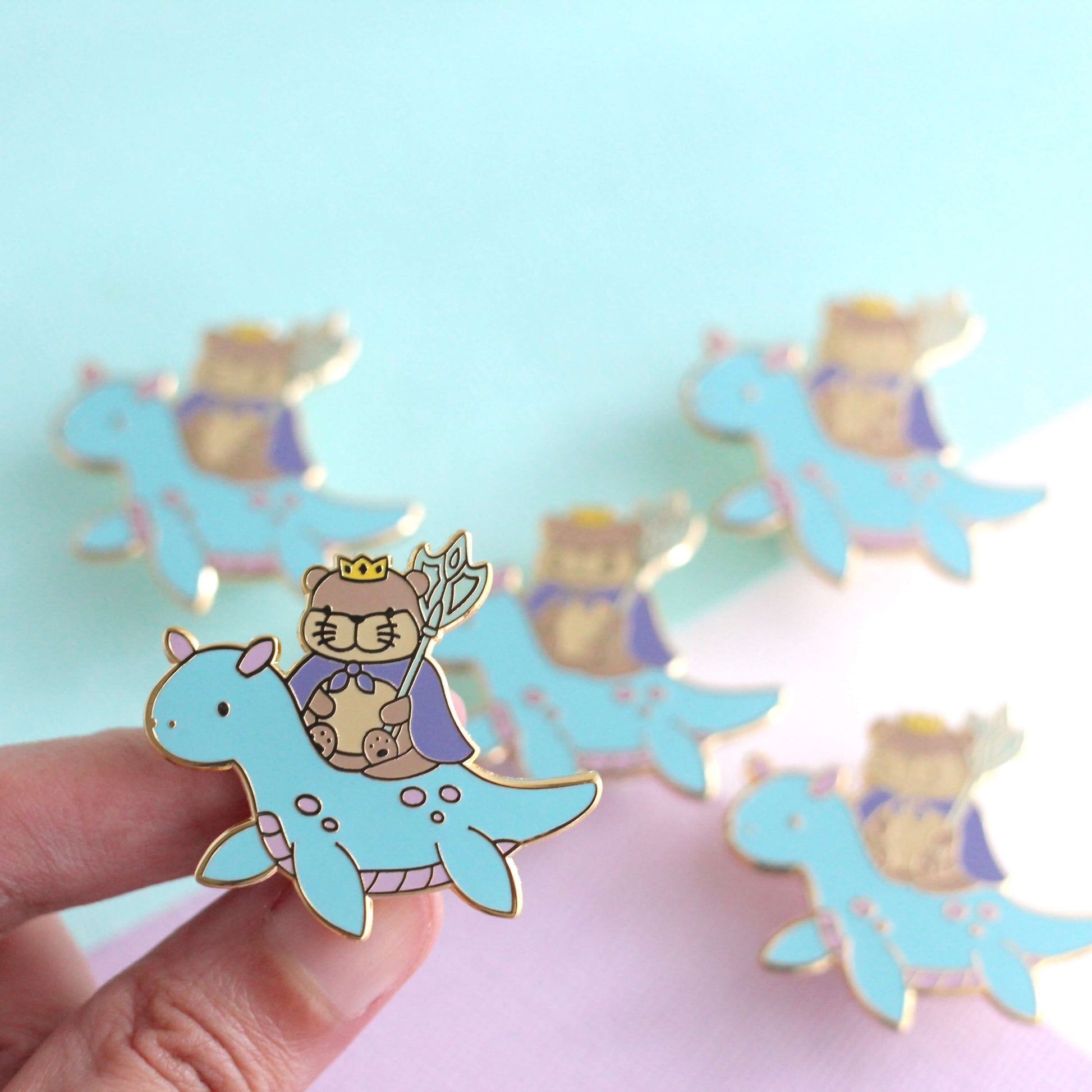 Broche en émail représentant le roi loutre chevauchant un dragon des mers (variante dragon bleu clair)