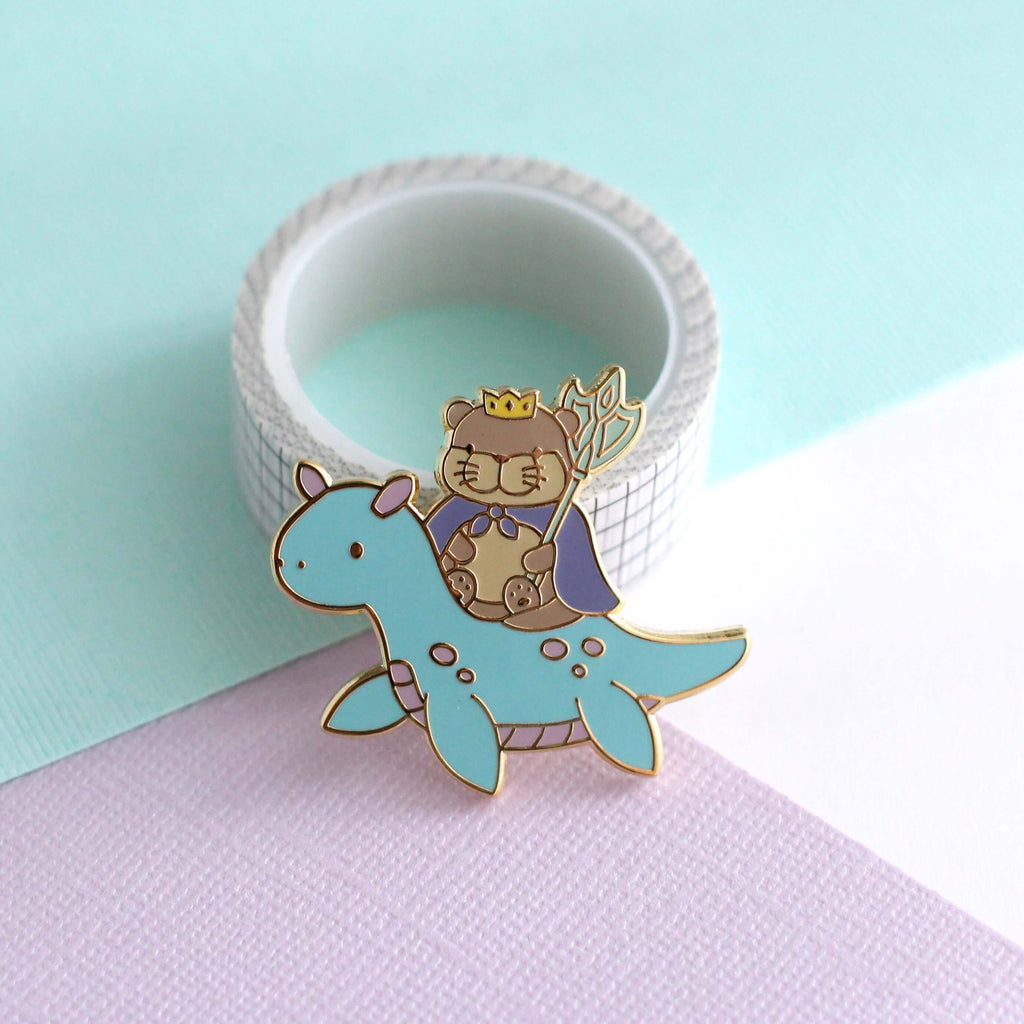 Broche en émail représentant le roi loutre chevauchant un dragon des mers (variante dragon bleu clair)