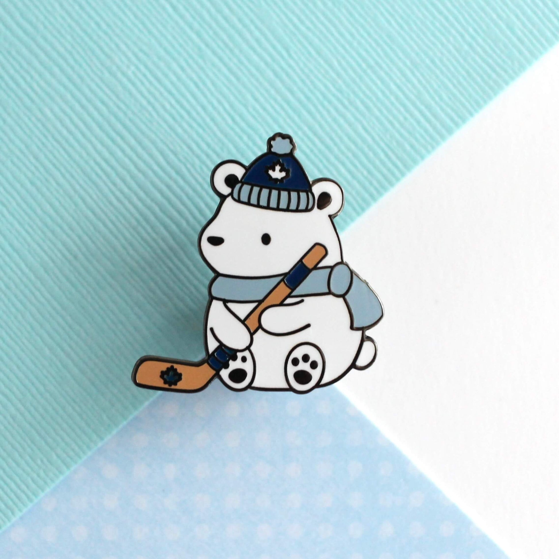 Broche en émail représentant un ours polaire jouant au hockey