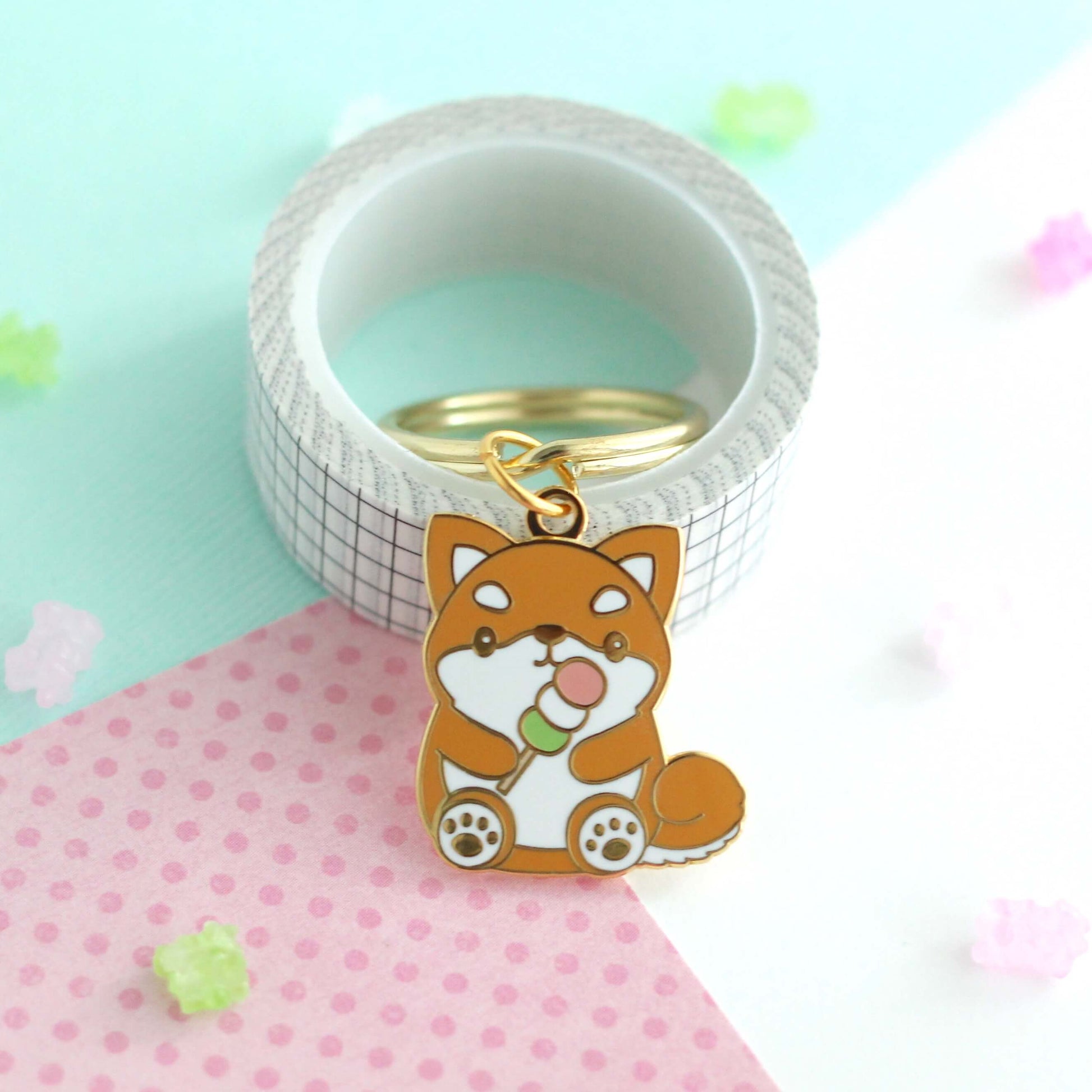 Shiba Inu tenant un porte-clés en émail Dango