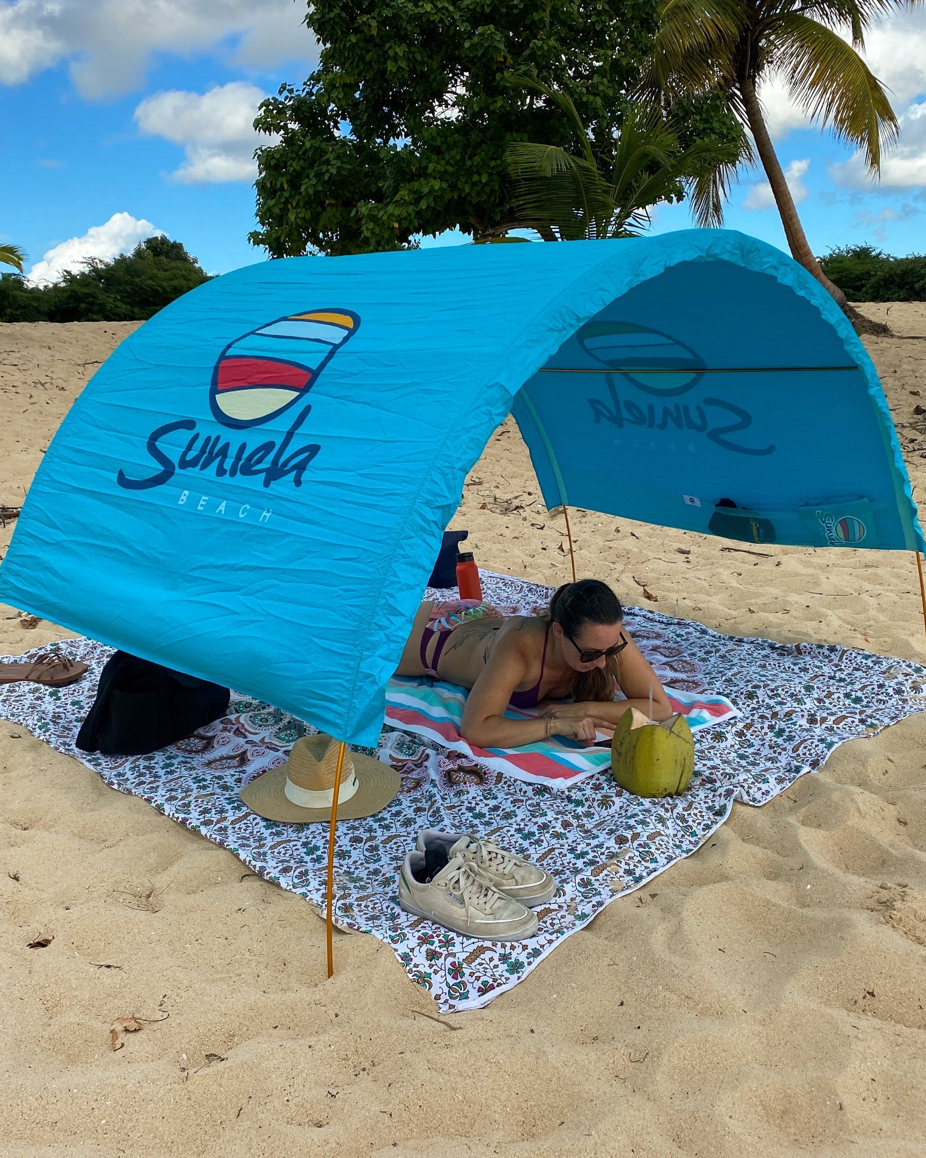 Turquoise Suniela cotton beach cabana providing shade on a tropical beach