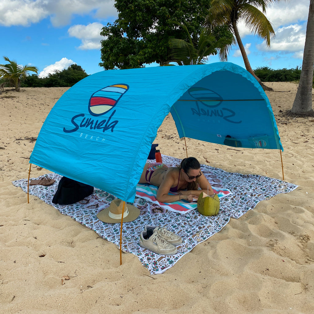 Turquoise Suniela cotton beach cabana providing shade on a tropical beach