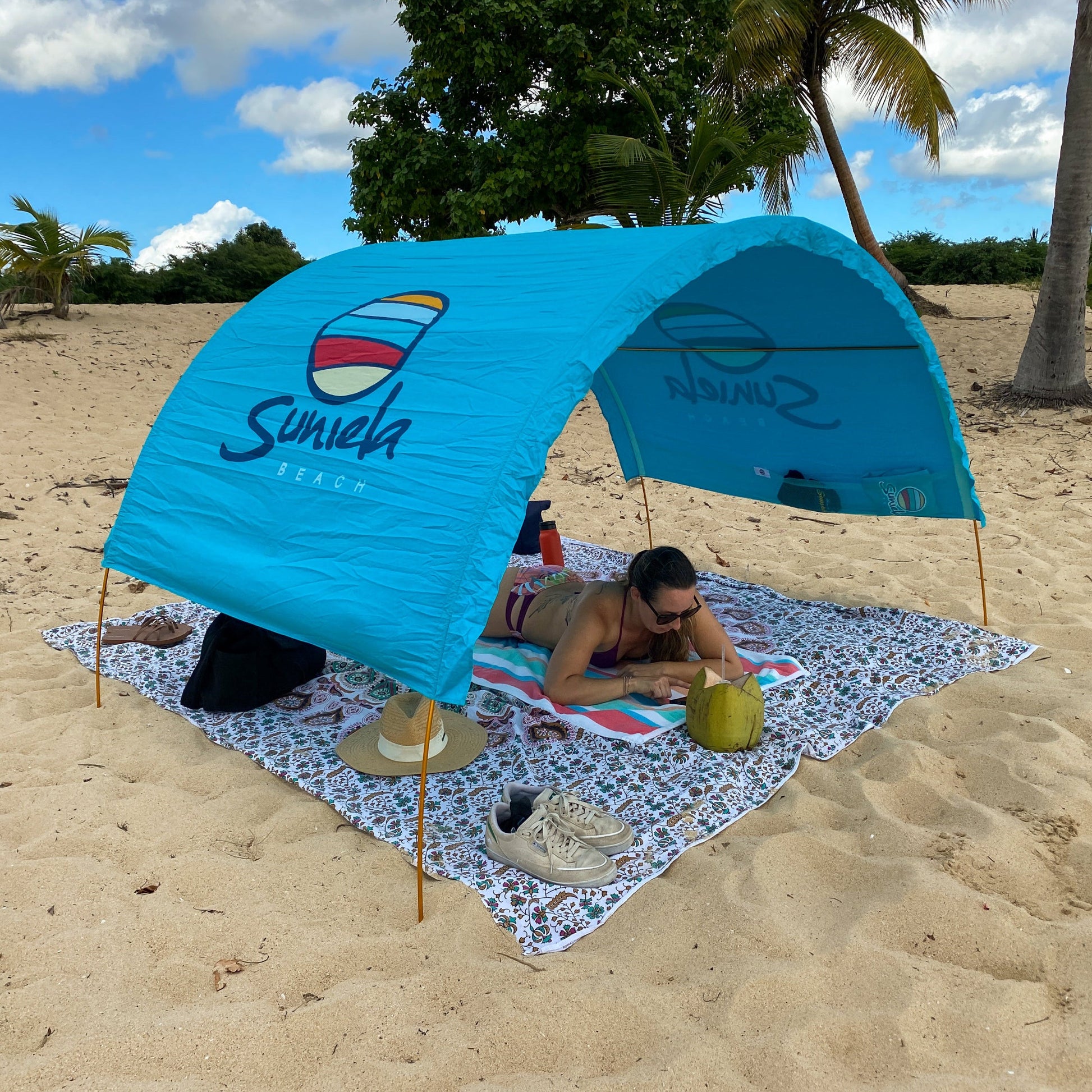 Turquoise Suniela cotton beach cabana providing shade on a tropical beach