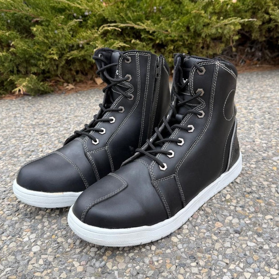 Bottes motardes pour homme. Cuir de vachette noir, semelle blanche, lacets et fermeture éclair latérale.
