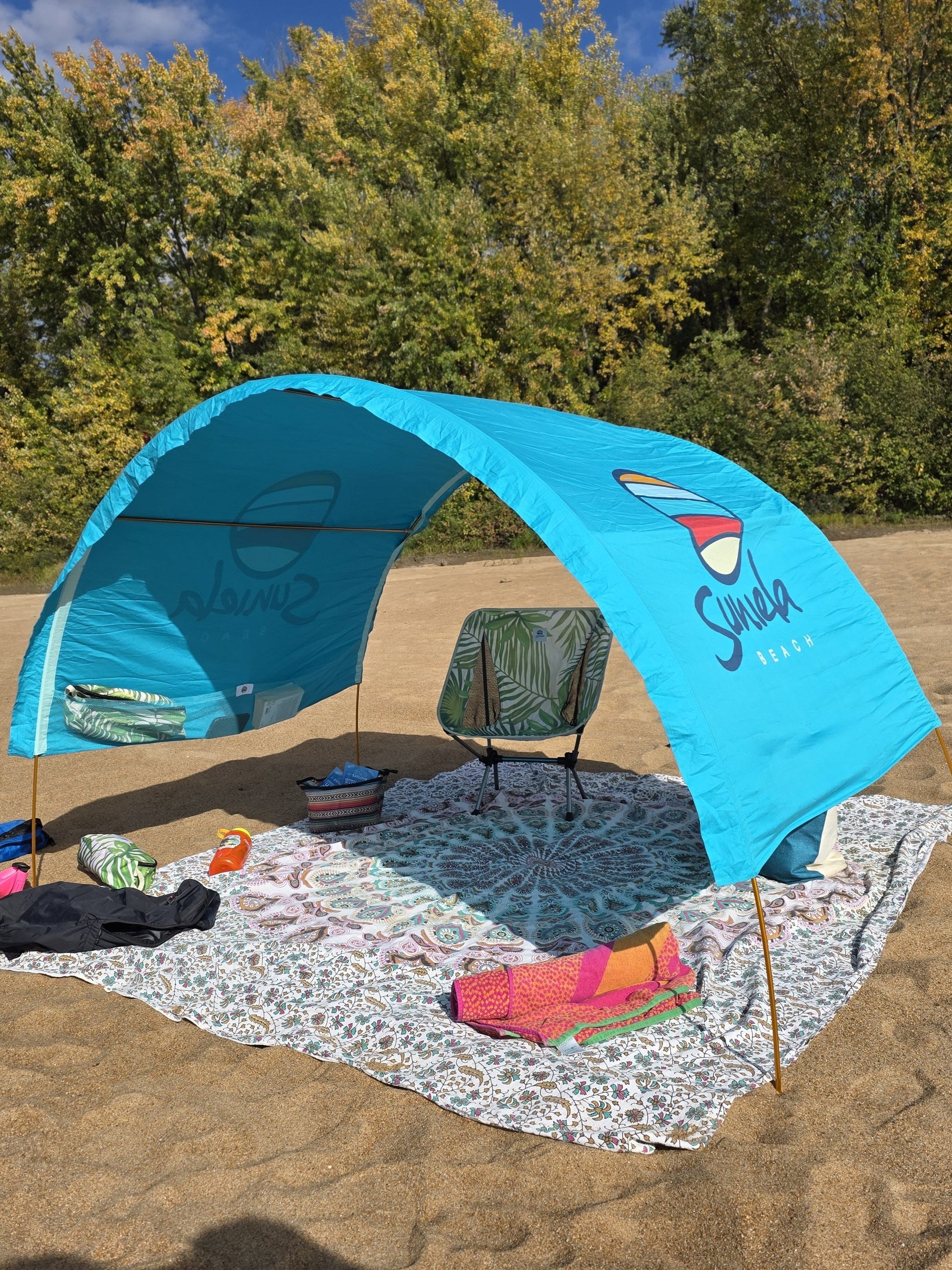 Turquoise Suniela shade cabana with palm beach chair beneath