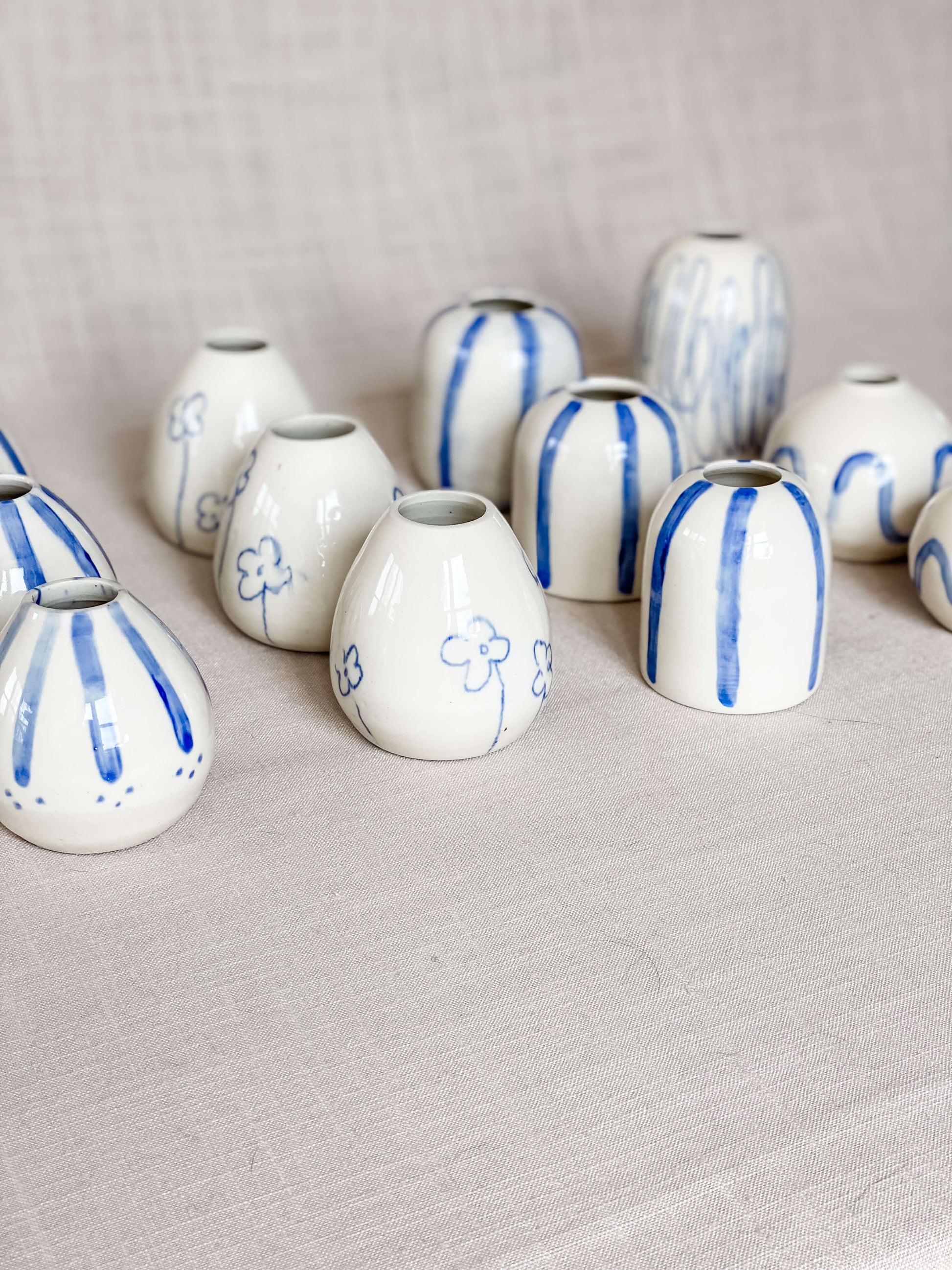 collection handmade porcelain blue white bud vases lined up in 4 rows