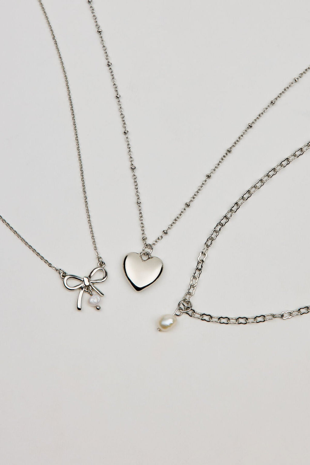 Ensemble de 3 colliers nœud, perle et cœur