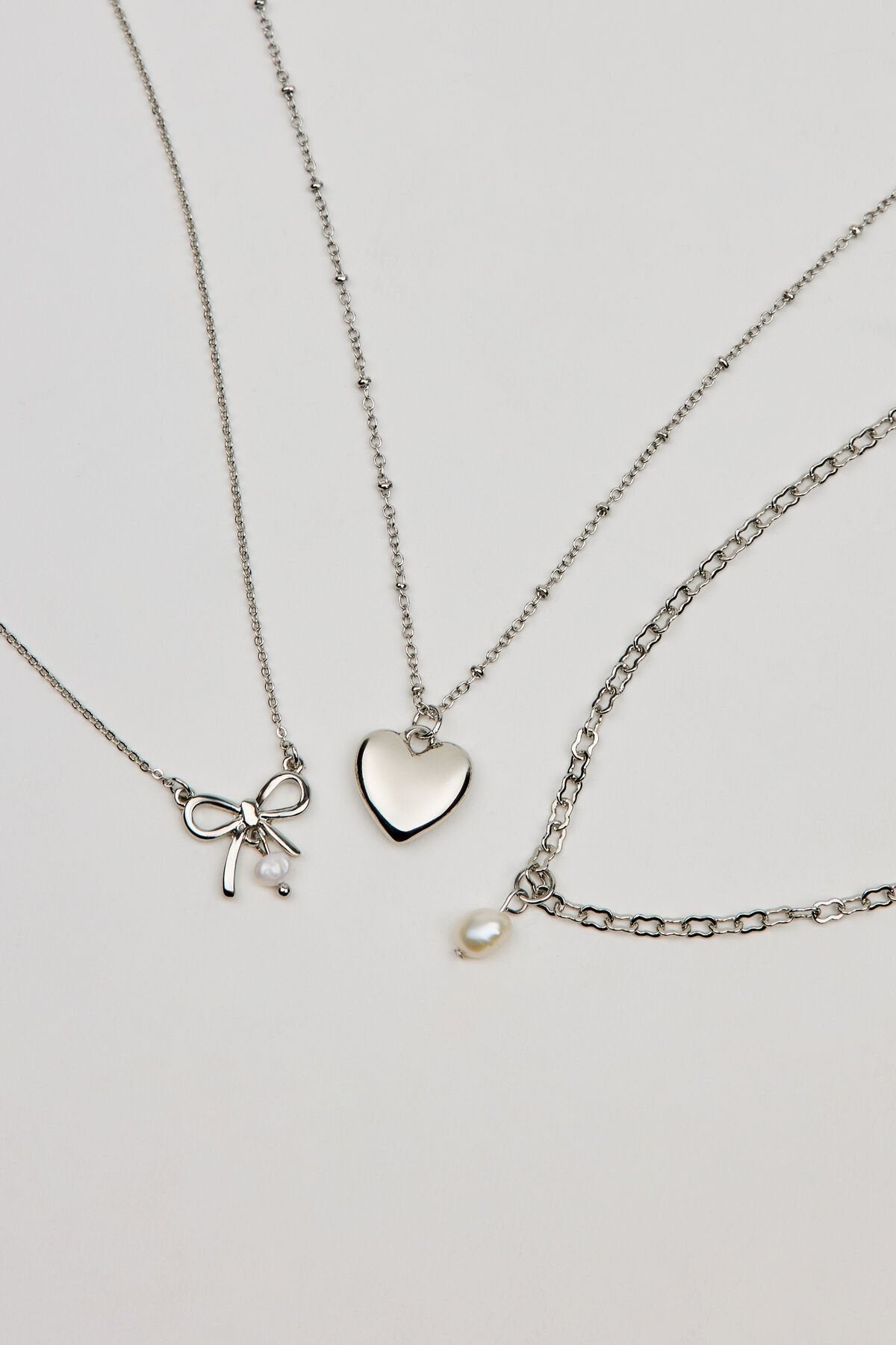 Ensemble de 3 colliers nœud, perle et cœur